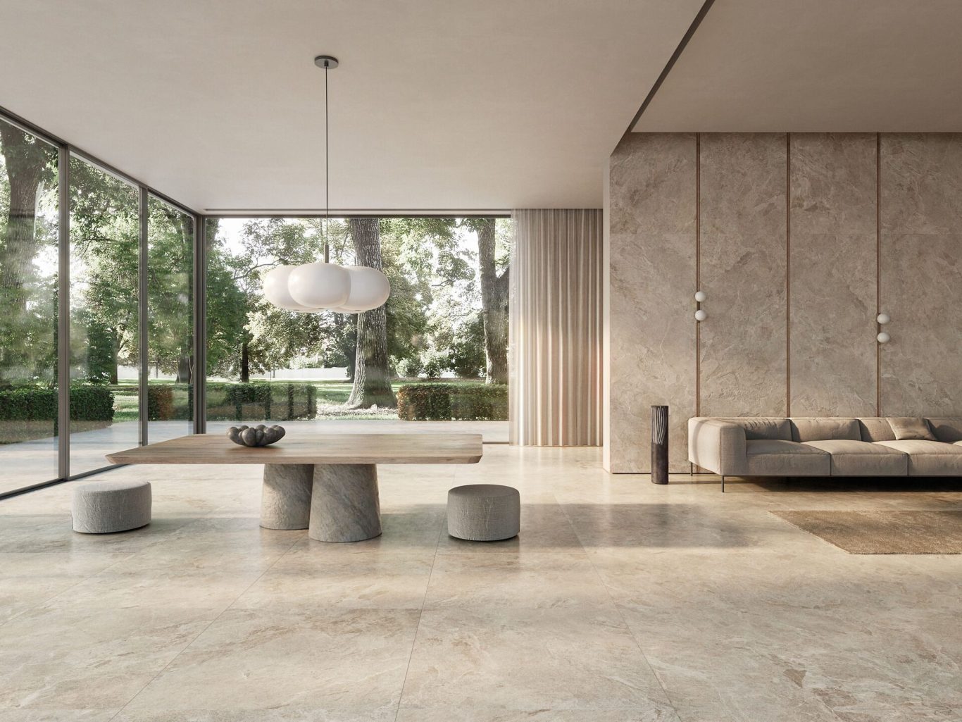 Sala moderna con paredes de piedra, mesa de piedra y sofá, rodeada de grandes ventanales.