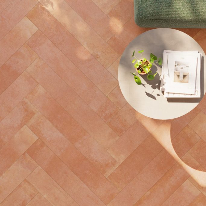 Suelo de madera clara con una mesa redonda y plantas junto a una revista.