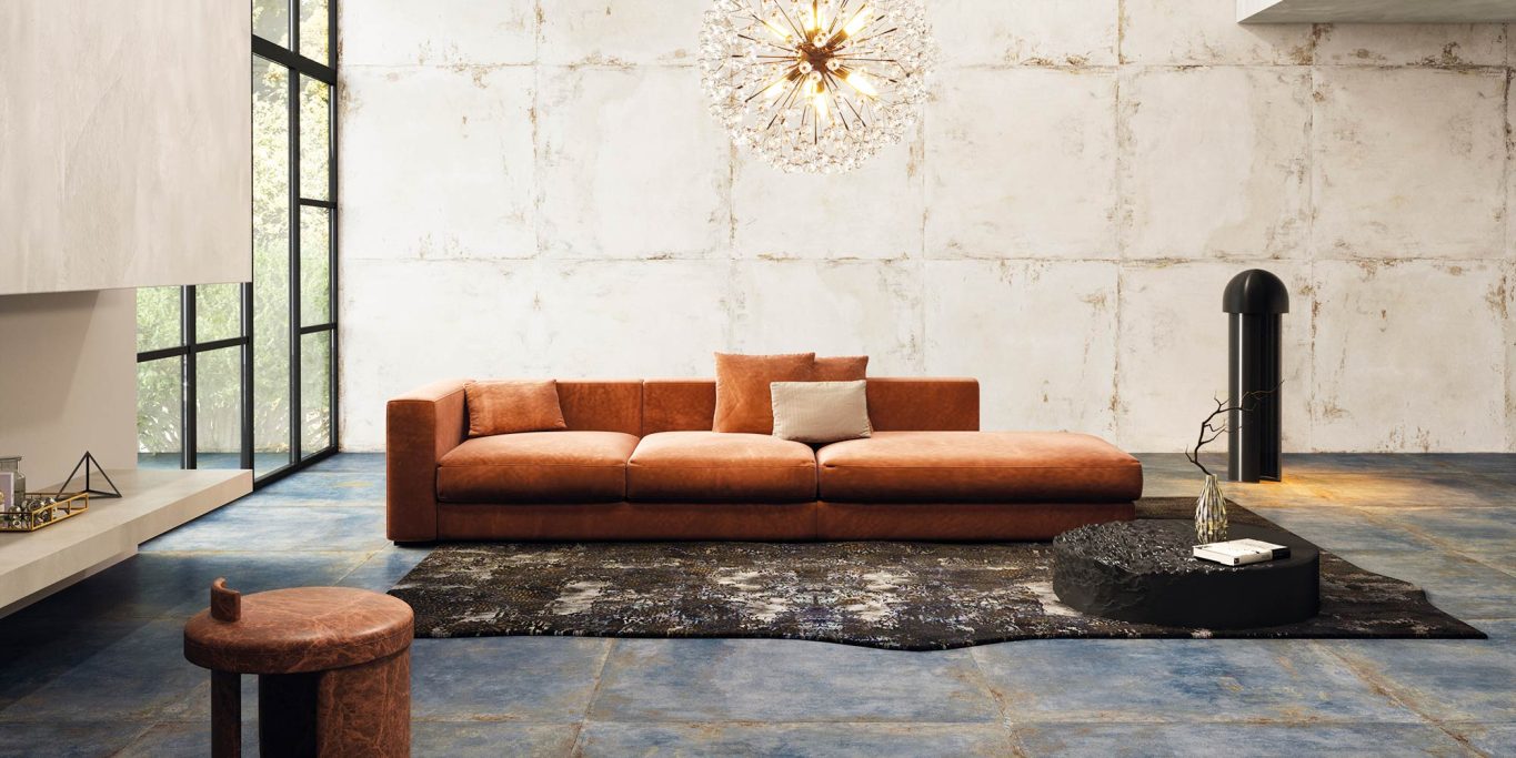 Sofá naranja moderno sobre una alfombra negra en un salón minimalista.
